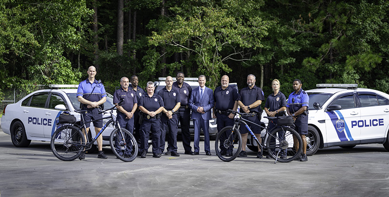 FSCJ Police and Chief Bass standing in front of police cars.